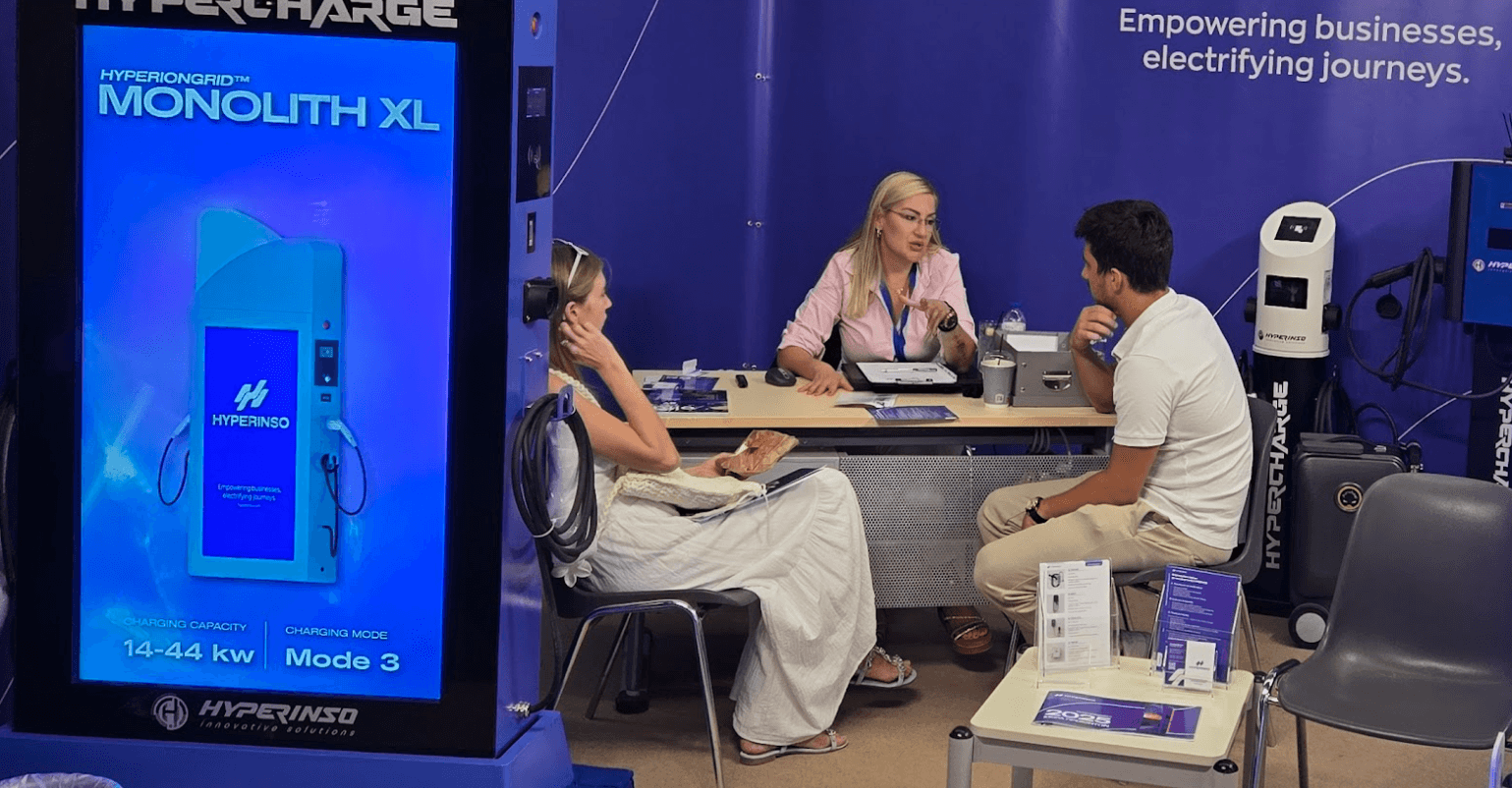 Hyperinso staff talking with visitors beside the Monolith XL charger at the TIF stand