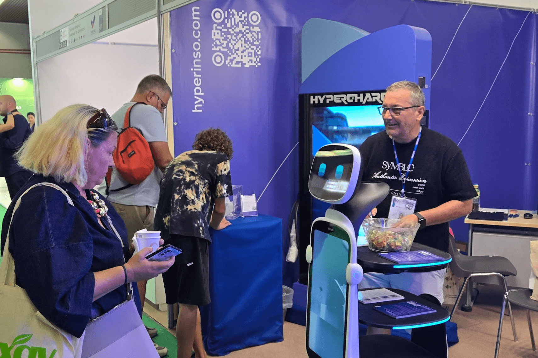 Visitors interacting with the service robot at the Hyperinso stand
